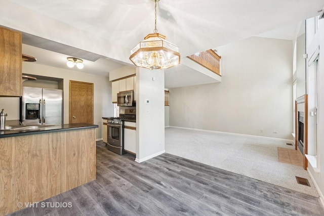 614 Hillview Ct, West Chicago, IL 60185 - kitchen featuring appliances with stainless steel finishes, dark countertops, dark wood-type flooring, and a chandelier