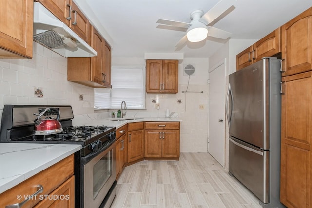 9739 S Ellis Ave, Chicago, IL 60628 - kitchen with appliances with stainless steel finishes, under cabinet range hood, brown cabinets, and a ceiling fan