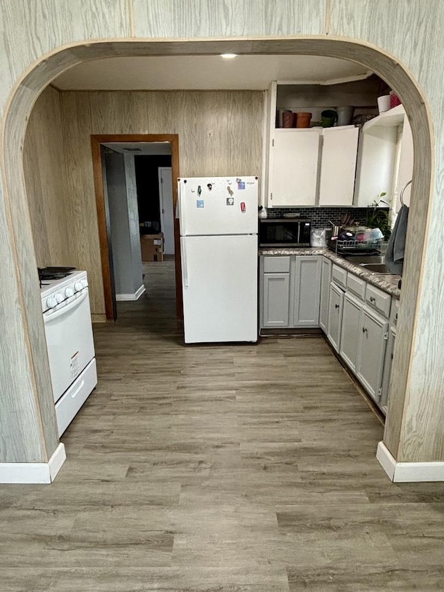1221 Nicholson St, Joliet, IL 60435 - kitchen featuring white appliances, light wood-type flooring, arched walkways, and white cabinetry