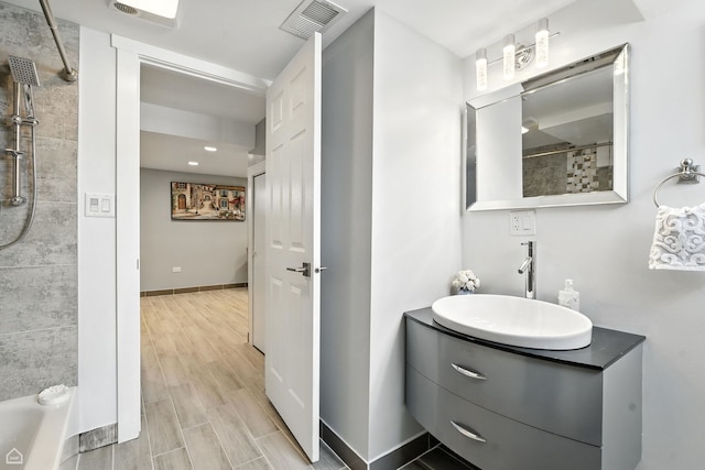 7515 W Roscoe St, Chicago, IL 60634 - bathroom featuring tiled shower, vanity, and wood finished floors