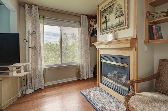 387 Essex Dr, Oswego, IL 60543 - living area featuring healthy amount of natural light, wood finished floors, and a glass covered fireplace