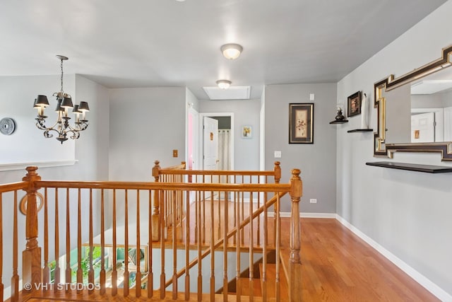 387 Essex Dr, Oswego, IL 60543 - hallway featuring an upstairs landing, wood finished floors, and a chandelier