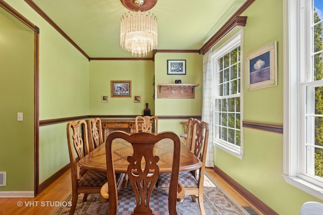 387 Essex Dr, Oswego, IL 60543 - dining area with a chandelier, healthy amount of natural light, wood finished floors, and ornamental molding