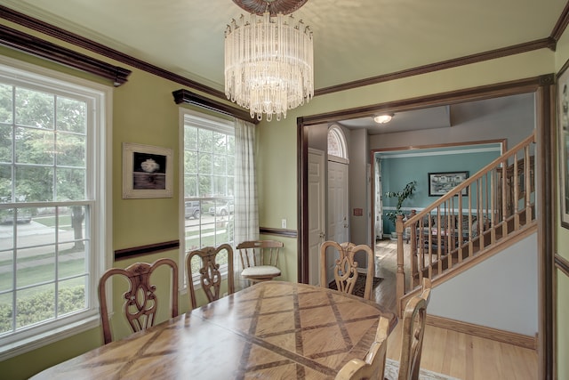 387 Essex Dr, Oswego, IL 60543 - dining room featuring healthy amount of natural light, a chandelier, wood finished floors, stairs, and ornamental molding