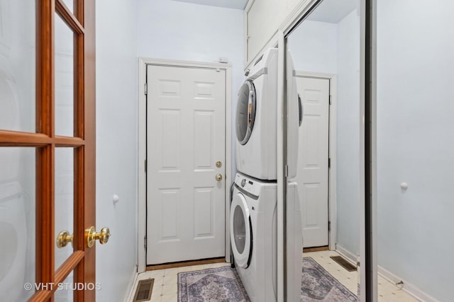 387 Essex Dr, Oswego, IL 60543 - washroom with stacked washing machine and dryer and baseboards