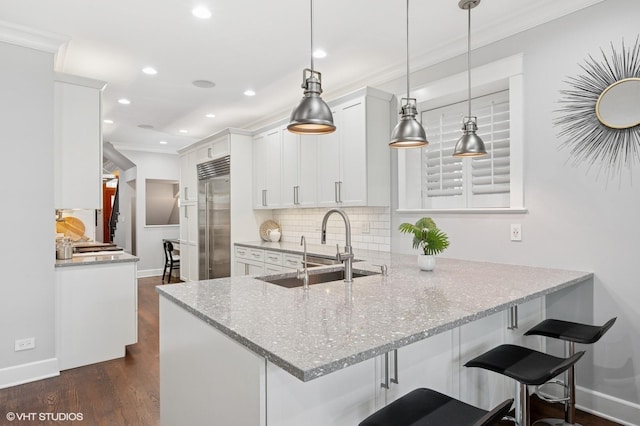 3715 N Wayne Ave, Chicago, IL 60613 - kitchen featuring built in refrigerator, ornamental molding, decorative backsplash, light stone counters, and recessed lighting