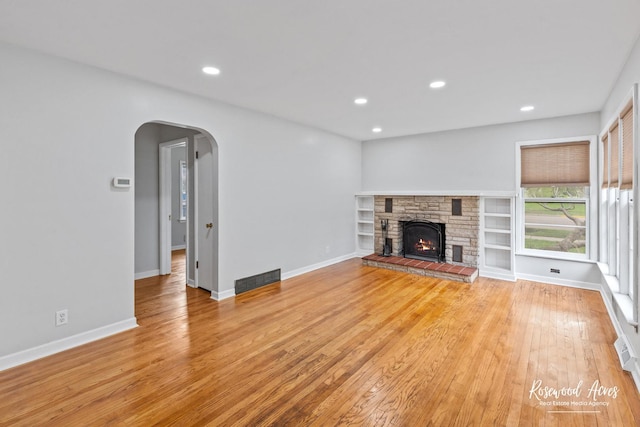 902 W Downer Pl, Aurora, IL 60506 - unfurnished living room featuring arched walkways, light wood finished floors, recessed lighting, and a fireplace