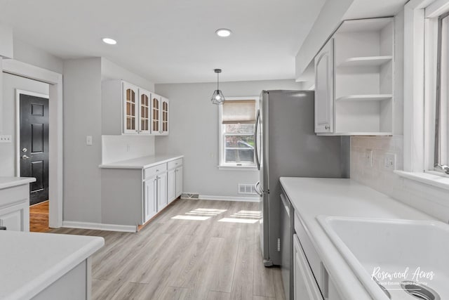 902 W Downer Pl, Aurora, IL 60506 - kitchen with glass insert cabinets, light wood-style floors, open shelves, backsplash, and light countertops