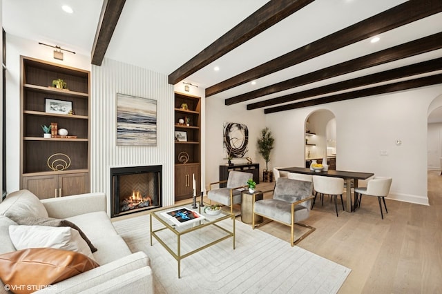 838 N Damen Ave Unit 1, Chicago, IL 60622 - living room featuring arched walkways, light wood finished floors, a fireplace, beamed ceiling, and recessed lighting
