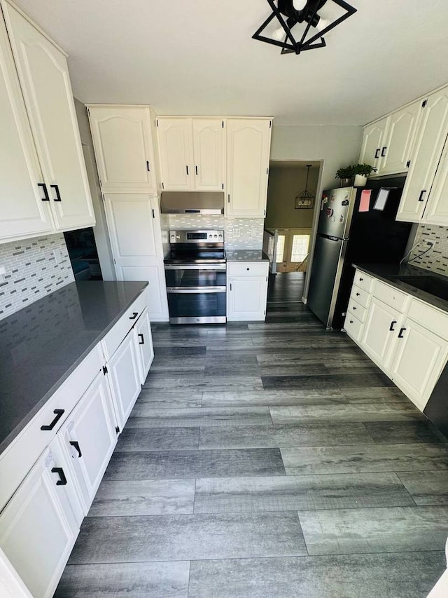 530 Cottonwood Cir, Bolingbrook, IL 60440 - kitchen featuring stainless steel appliances, under cabinet range hood, dark countertops, white cabinetry, and decorative backsplash