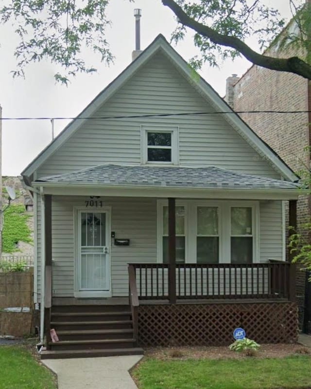 bungalow-style house featuring covered porch and a chimney