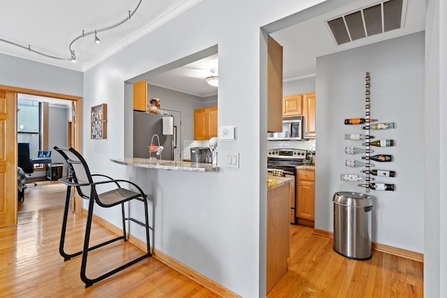 431 S Dearborn St Unit 1303, Chicago, IL 60605 - kitchen with appliances with stainless steel finishes, ornamental molding, light wood-type flooring, a breakfast bar area, and light stone countertops