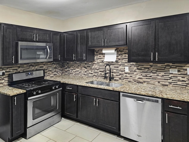 301 Cornell Ave, Calumet City, IL 60409 - kitchen featuring appliances with stainless steel finishes, dark cabinets, backsplash, and light tile patterned floors