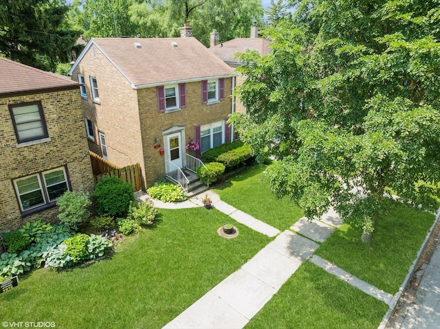 3837 Kirk St, Skokie, IL 60076 - view of front of house featuring brick siding, a front lawn, a chimney, and roof with shingles
