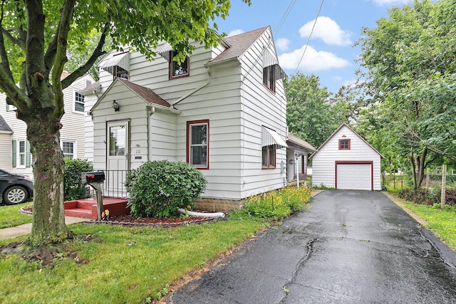 218 Mason Ct, Sycamore, IL 60178 - view of front facade with an outdoor structure, a detached garage, roof with shingles, and driveway