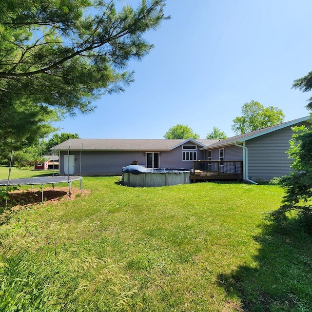 1932 N 2653rd Rd, Ottawa, IL 61350 - view of green lawn featuring a wooden deck, a trampoline, and a covered pool