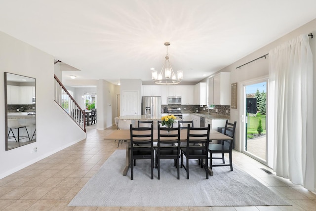9054 Clinnin Ln, Huntley, IL 60142 - dining room with light tile patterned floors, a chandelier, and stairway