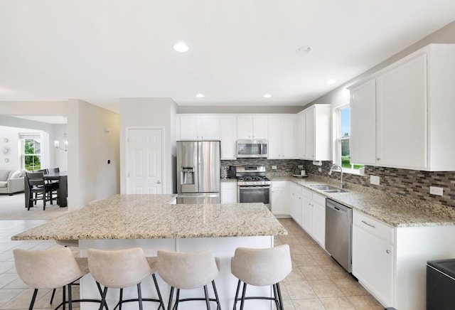 9054 Clinnin Ln, Huntley, IL 60142 - kitchen with appliances with stainless steel finishes, a kitchen island, decorative backsplash, a breakfast bar area, and recessed lighting