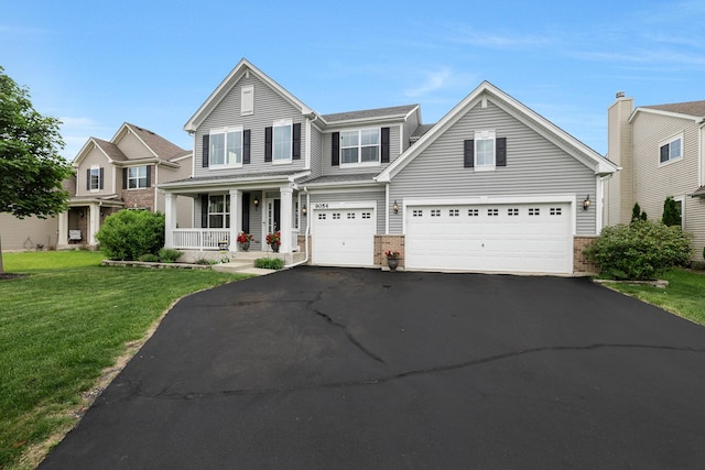 9054 Clinnin Ln, Huntley, IL 60142 - traditional home with covered porch, asphalt driveway, a front yard, brick siding, and an attached garage