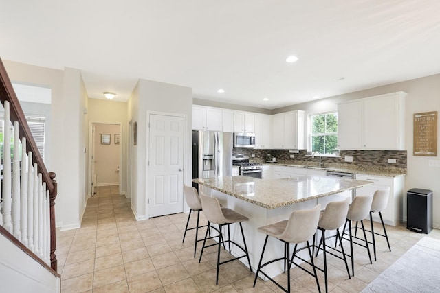 9054 Clinnin Ln, Huntley, IL 60142 - kitchen with stainless steel appliances, a center island, tasteful backsplash, white cabinetry, and recessed lighting