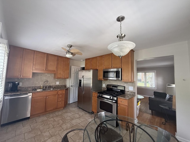 1757 Linden St, Des Plaines, IL 60018 - kitchen featuring appliances with stainless steel finishes, a ceiling fan, decorative backsplash, brown cabinets, and dark stone countertops