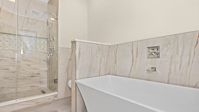 336 E Pershing Rd, Chicago, IL 60653 - full bathroom with marble look tile flooring, tile walls, a shower stall, and a soaking tub