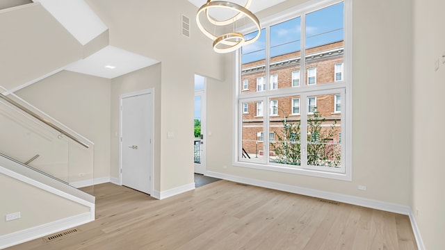 336 E Pershing Rd, Chicago, IL 60653 - unfurnished dining area featuring wood finished floors, a chandelier, and a towering ceiling