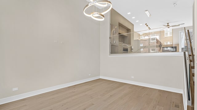336 E Pershing Rd, Chicago, IL 60653 - unfurnished dining area with wood finished floors, ceiling fan, and a chandelier