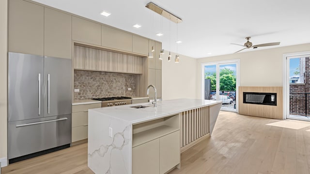 336 E Pershing Rd, Chicago, IL 60653 - kitchen featuring appliances with stainless steel finishes, light wood finished floors, decorative backsplash, cream cabinets, and modern cabinets
