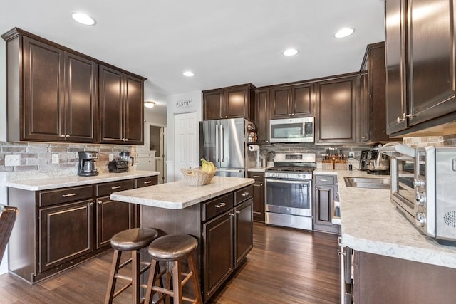 956 Tuscany Trl, Hampshire, IL 60140 - kitchen featuring appliances with stainless steel finishes, dark brown cabinets, tasteful backsplash, light countertops, and recessed lighting
