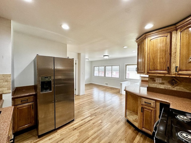 2111 N 75th Ct, Elmwood Park, IL 60707 - kitchen featuring stainless steel fridge with ice dispenser, black range, light wood-style floors, decorative backsplash, and brown cabinetry