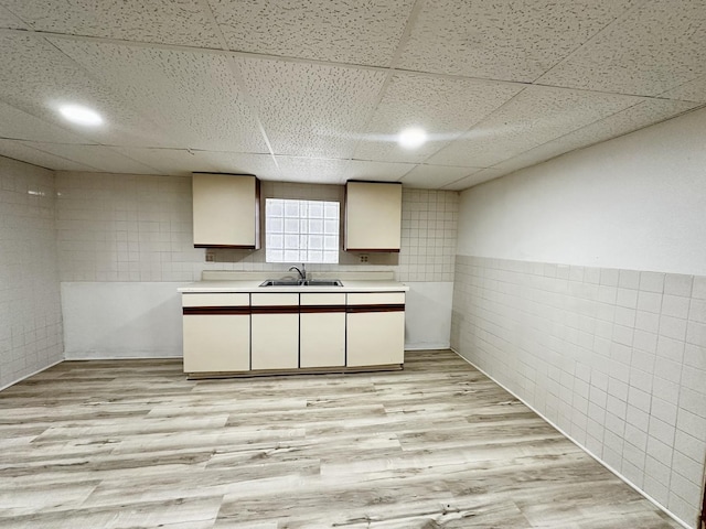 2111 N 75th Ct, Elmwood Park, IL 60707 - kitchen with tile walls, light countertops, a drop ceiling, light wood-type flooring, and wainscoting