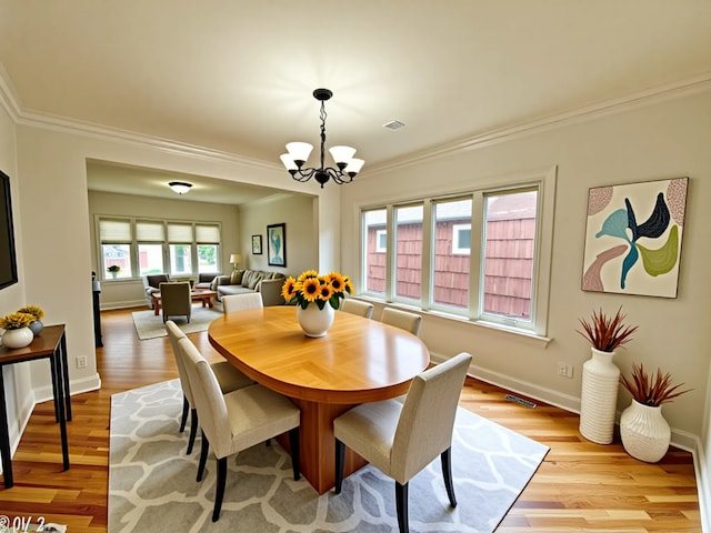 2111 N 75th Ct, Elmwood Park, IL 60707 - dining space featuring crown molding, a chandelier, and light wood-type flooring