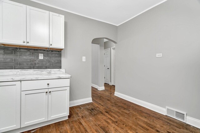 8107 S Princeton Ave, Chicago, IL 60620 - kitchen with arched walkways, crown molding, tasteful backsplash, white cabinets, and dark wood-style flooring