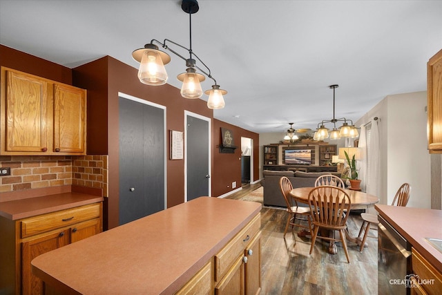 3402 Hoffman St, Plano, IL 60545 - kitchen with stainless steel dishwasher, dark wood finished floors, decorative light fixtures, decorative backsplash, and a kitchen island