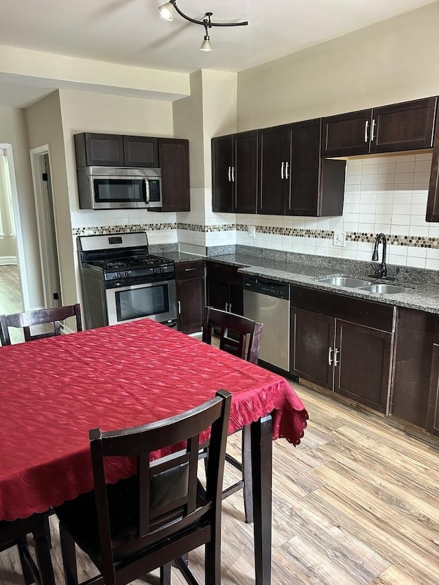 2122 N Lorel Ave, Chicago, IL 60639 - kitchen featuring stainless steel appliances, decorative backsplash, and light wood-style floors