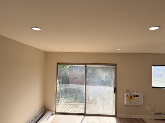 18550 Torrence Ave Unit 25, Lansing, IL 60438 - unfurnished room with a wall unit AC, recessed lighting, baseboard heating, healthy amount of natural light, and wood finished floors