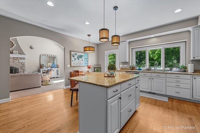 6407 Kingsbridge Dr, Cary, IL 60013 - kitchen with a kitchen island, light wood-type flooring, recessed lighting, decorative light fixtures, and a kitchen breakfast bar
