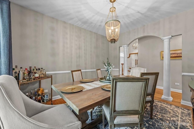 6407 Kingsbridge Dr, Cary, IL 60013 - dining area featuring ornate columns, arched walkways, a chandelier, and wood finished floors