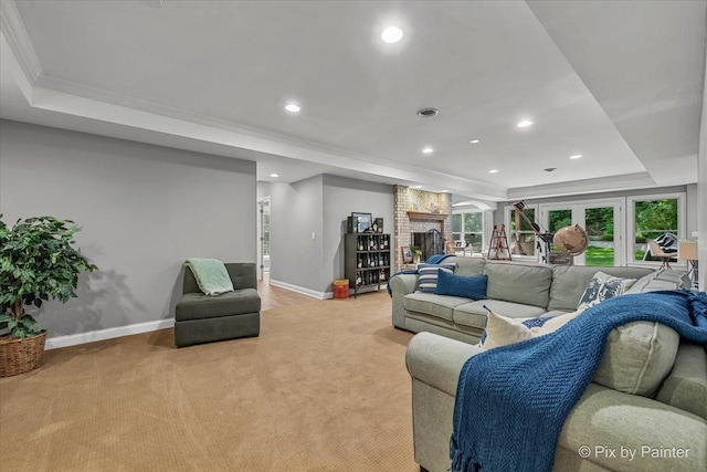6407 Kingsbridge Dr, Cary, IL 60013 - living area with a tray ceiling, light colored carpet, crown molding, a brick fireplace, and recessed lighting