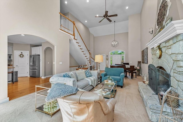 6407 Kingsbridge Dr, Cary, IL 60013 - living area with arched walkways, a towering ceiling, stairs, a ceiling fan, and recessed lighting