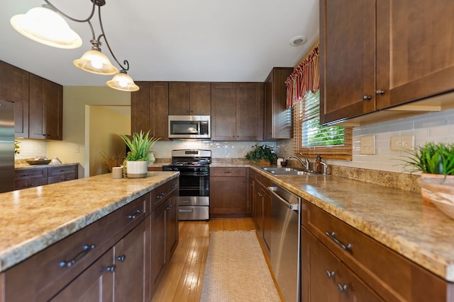 12 White Oak Ct, Algonquin, IL 60102 - kitchen with stainless steel appliances, tasteful backsplash, light wood-type flooring, decorative light fixtures, and light stone countertops