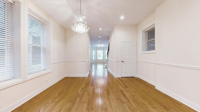 4450 S Prairie Ave, Chicago, IL 60653 - hallway featuring light wood-style flooring, a chandelier, and recessed lighting