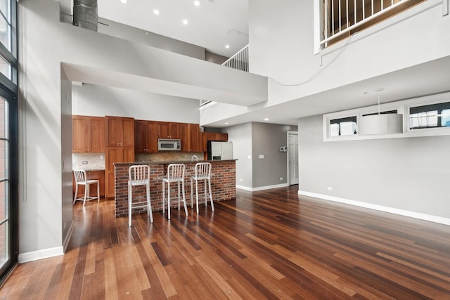 70 E 18th St Unit 4E, Chicago, IL 60616 - kitchen with appliances with stainless steel finishes, a towering ceiling, dark wood-style flooring, a breakfast bar area, and open floor plan