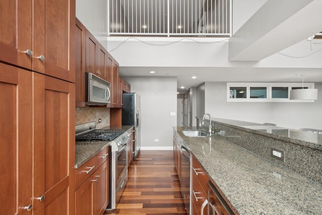 70 E 18th St Unit 4E, Chicago, IL 60616 - kitchen with appliances with stainless steel finishes, dark wood-style flooring, dark stone countertops, tasteful backsplash, and brown cabinetry