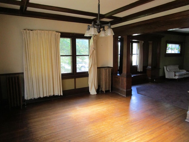 1101 N Hart St, Harvard, IL 60033 - unfurnished dining area featuring a chandelier, radiator heating unit, wood finished floors, coffered ceiling, and beam ceiling