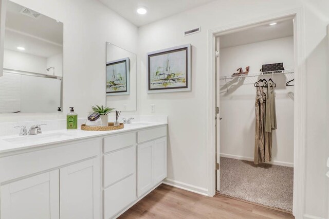 506 Adirondack Dr, Joliet, IL 60436 - bathroom featuring double vanity, wood finished floors, a walk in closet, a shower, and recessed lighting