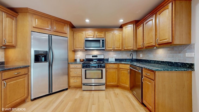 6333 N Milwaukee Ave Unit 2E, Chicago, IL 60646 - kitchen featuring appliances with stainless steel finishes, light wood finished floors, dark stone counters, backsplash, and brown cabinets