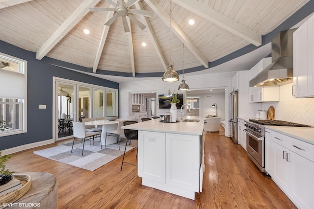301 E 59th St, Hinsdale, IL 60521 - kitchen featuring stainless steel appliances, wall chimney range hood, light countertops, white cabinetry, and light wood-style flooring