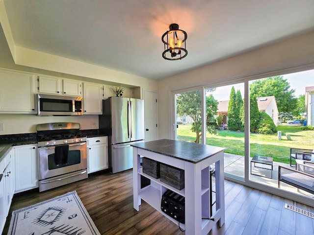 2440 Pebblewood Ct, Aurora, IL 60506 - kitchen with stainless steel appliances, open shelves, dark countertops, and dark wood-style flooring